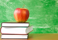 books with apple against dirty chalkboard