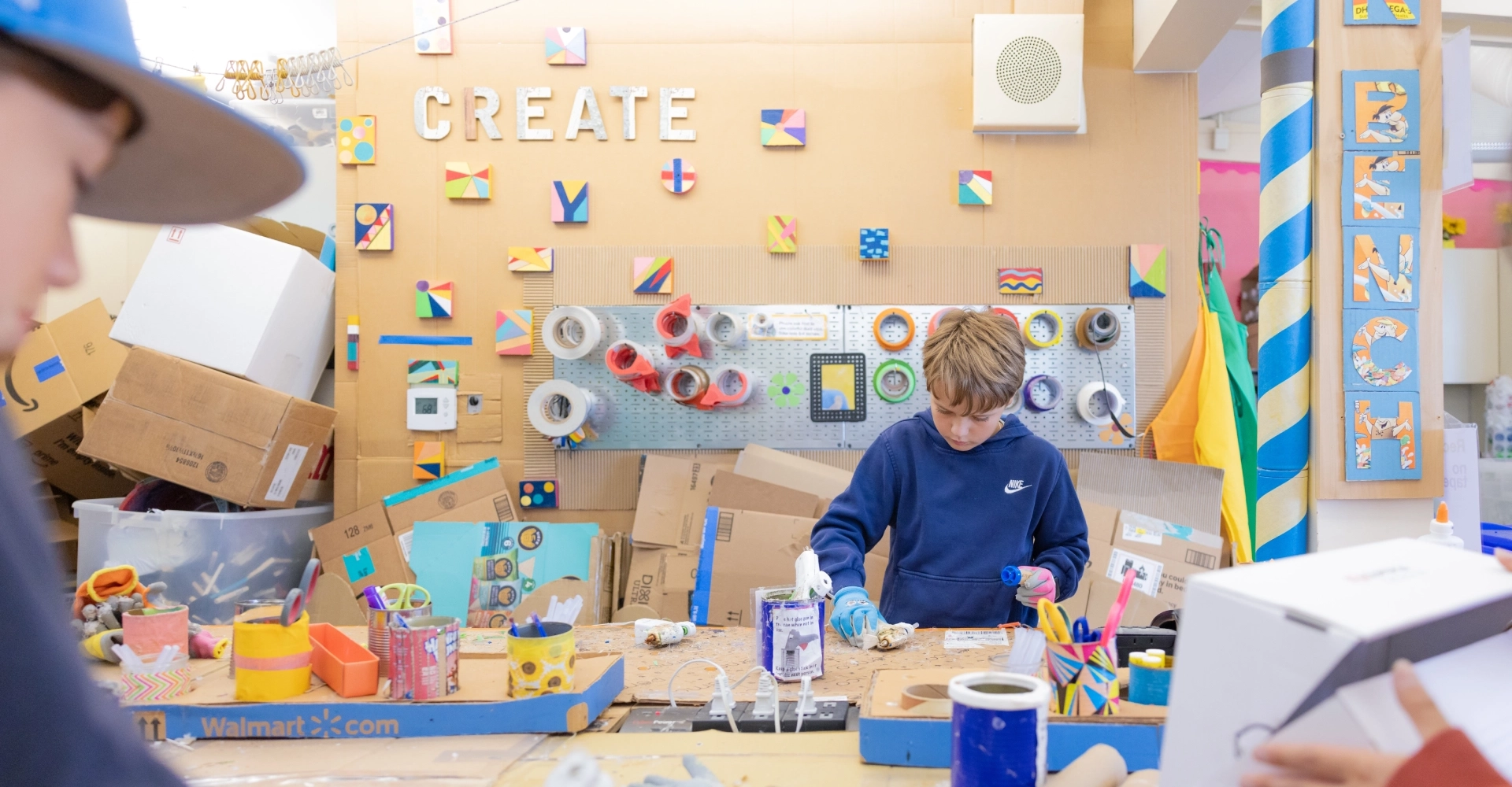 A child engaged in a colorful arts and crafts project in a creative classroom.