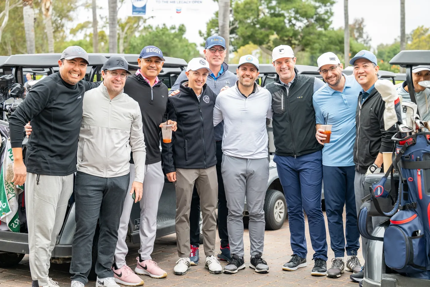 Group of men smiling together at a golf event.