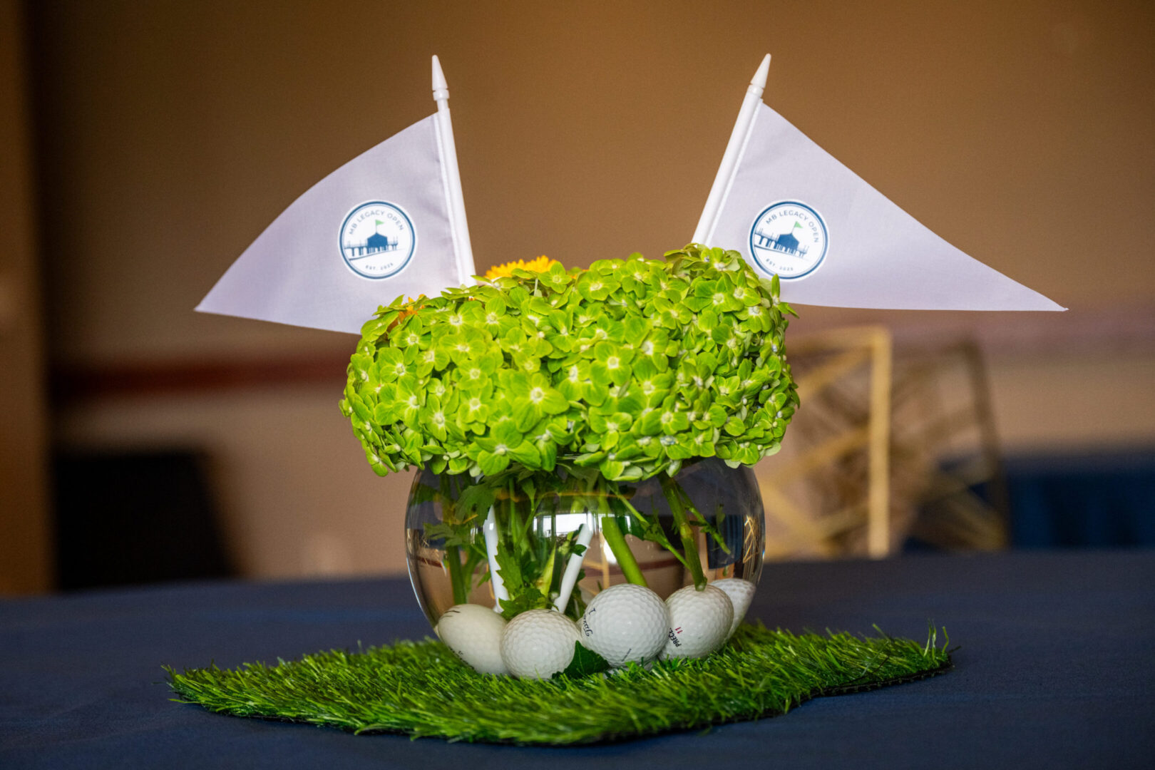 Golf-themed centerpiece with flowers and flags.