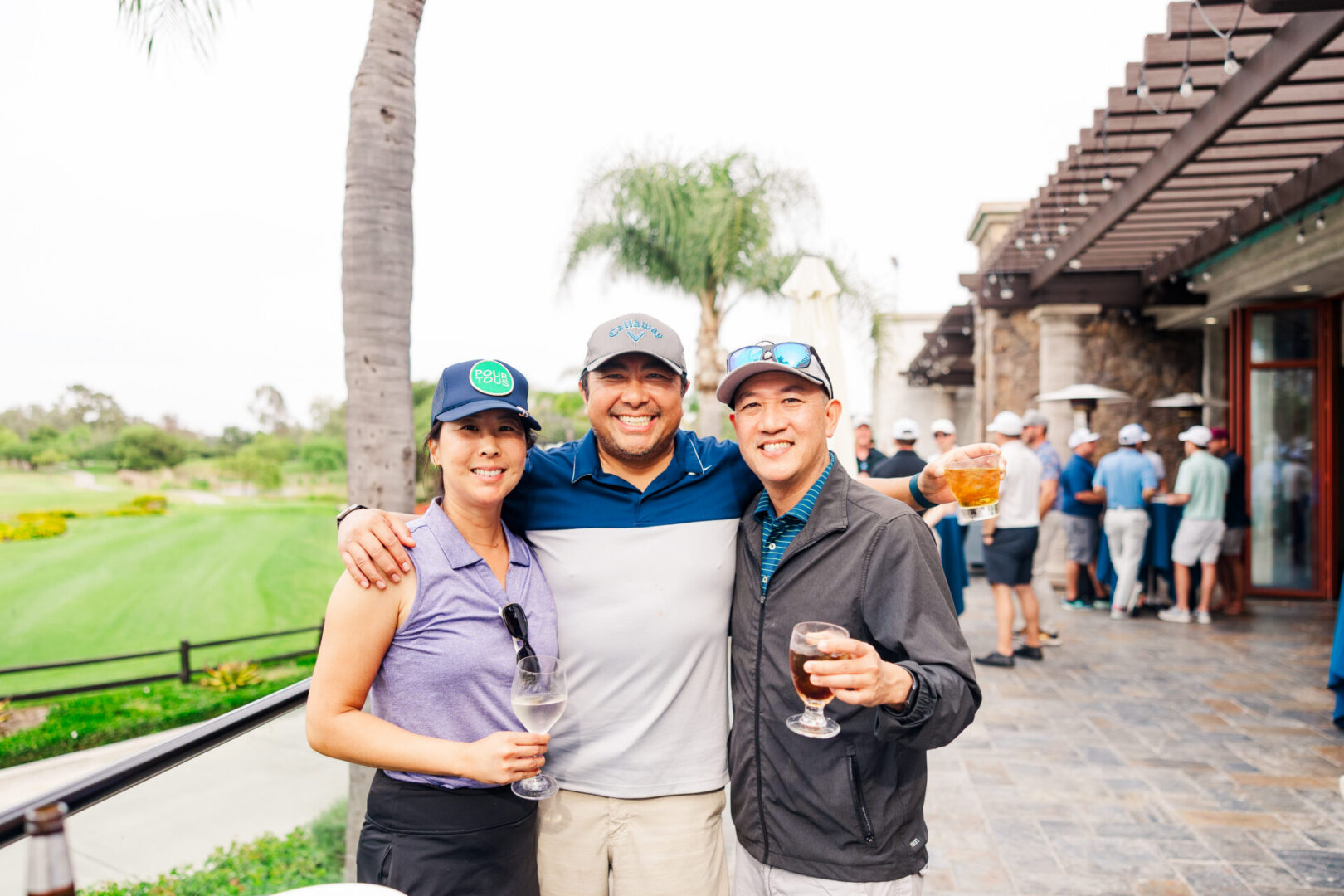 Friends enjoying drinks at a golf event.