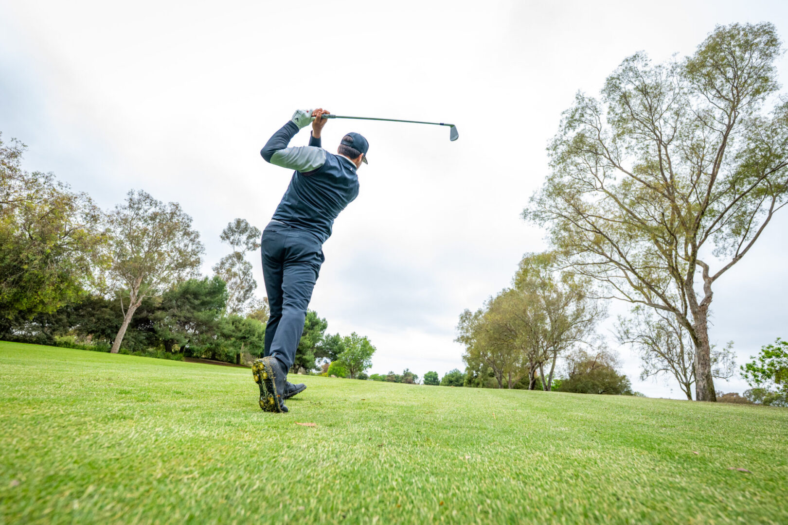 Golfer executing a swing on the course.